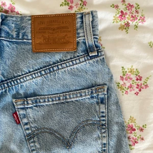 Levi's blå jeansshorts - Säljer ett par klassiska blå jeansshorts från Levi's. De har en hög midja och en avslappnad passform. 