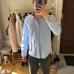 Blå rutig skjorta från Ralph Lauren (40/41) - Säljer en stilren blå rutig skjorta från Ralph Lauren. Skjortan har långa ärmar och knappar framtill. Perfekt för en klassisk look. Storlek 40/41. Jag är 183cm 