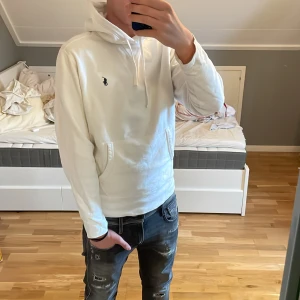 Vit hoodie från Ralph Lauren - Säljer en stilren vit hoodie från Ralph Lauren med det klassiska logotypbroderiet på bröstet. Modellen är 178 cm 65 kg ish. Priset är ej helt hugget i sten, skambud ignoreras 