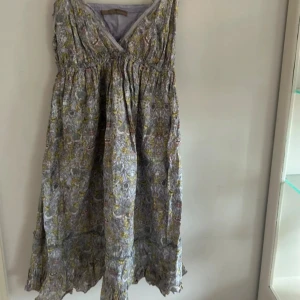 Blommig klänning med smala axelband - Säljer denna underbara sommar klänning som är så finn men tyvärr för stor för mig, dragkedjan på sidan är lite knepig den går att knäppa och öpnna men är trög, skulle säga att storleks mesigt är den en s eller smal m