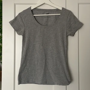 Grå t-shirt från 157 - Säljer en enkel och stilren grå t-shirt från 157. Den är tillverkad i en mjuk bomullsblandning med korta ärmar och rund halsringning. Perfekt basplagg för alla tillfällen!