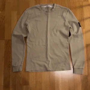 Beige tröja från Calvin Klein Jeans - Säljer nu denna snygga tröja från Calvin Klein. Den har en ganska simpel look med ett snyggt märke på armen. Den är inte så tjock så perfekt nu till våren eller sommarkvällar. Skriv gärna om du vill ha mer bilder eller om du har några frågor. Pris kan även diskuteras vid snabb affär