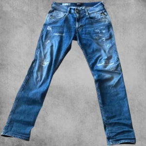 Blå jeans från Replay - Snygga blå jeans från Replay med slitna detaljer och en klassisk femficksdesign. De har en normal passform och är tillverkade i denim. Perfekta för en avslappnad stil.