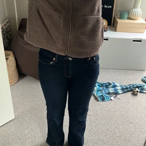 Mörkblå jeans - Snygga mörkblå jeansbyxor med normal passform och klassisk design. Byxorna har fem fickor och en knappgylf. Perfekta för en stilren look.