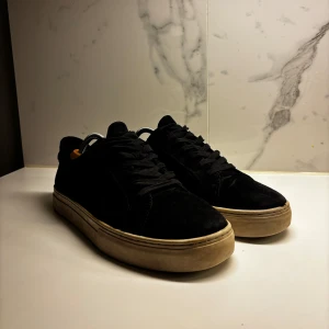 Marinblå sneakers i mocka från Vagabond - Snygga svarta sneakers i mocka med en stilren design. Skorna har en rund tå och snörning framtill. Sulan är i en kontrasterande vit som ger en cool look. Perfekta för en avslappnad stil. Sulan skulle behöva sig en tvätt!