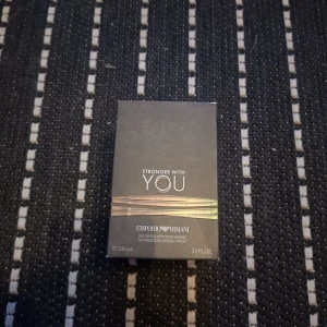 Stronger With You Eau de Toilette från Emporio Armani - Säljer en elegant och maskulin parfym, Stronger With You, från Emporio Armani. Flaskan är stilren med en rundad kork och rymmer 100 ml. Doften är intensiv och modern, perfekt för den självsäkra mannen. En tidlös doft som passar alla tillfällen.