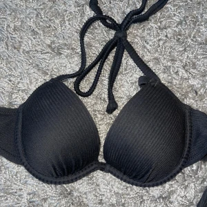 Svart ribbad bikiniöverdel - Snygg svart bikiniöverdel med ribbad struktur och push up. Aldrig använd