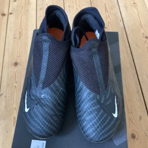 Nike Phantom Fotbollskor - Säljer gamla fotbollsskor. Använda en halv säsong pågrund av att de blev för små. Storlek 42,5/27cm. En liten skada på skorna men det är inget som stör. Skriv om du undrar något.