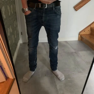 Blå Replay Jondrill jeans - Snygga blå Replay Jondrill jeans med en tight passform. De har en klassisk femficksdesign och subtila slitningar för en trendig look. Perfekta för dig som gillar en stilren och modern stil.