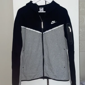 Nike Tech Fleece - Fräsch Nike Tech Fleece i svart och grå! Köpt på JD för 1349 kr, i nyskick förutom en liten blå fläck på vita strecket (knappt synlig). Otroligt bekväm och stilren – perfekt för både vardag och träning.