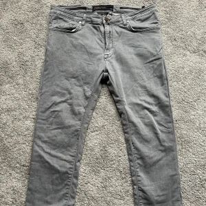 Grå jeansbyxor från Jacob Cohen - Snygga grå jeansbyxor från Jacob Cohen med klassisk femficksdesign och raka ben. 10/10 skick använd fåtal gånger. Pris kan diskuteras vid snabb affär 