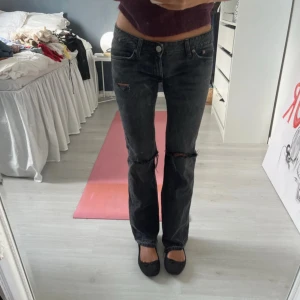 Svarta bootcut jeans från Zara - Säljer ett par svarta jeans från Zara med bootcut passform och låg midja. Jeansen har slitna detaljer vid knäna och klassisk femficksdesign. Materialet är jeans med en mörk tvätt som ger en cool vibe. Perfekt för dig som gillar en avslappnad och trendig stil. Sytt om dom själv till lågmidjat! Strl 38 men skulle säga 34/36 efter att sytt om dom