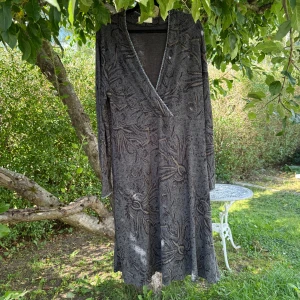 Grå långklänning med blommigt mönster - Säljer en grå långklänning med blommigt mönster och omlott-v-ringning. Klänningen har långa ärmar och är tillverkad i mjukt, stickat material. Snygga detaljer vid halsringningen och ett diskret mönster som ger en cool vintage vibe. Från märket Cream. Vet inte exakt storlek då storlekslappen inte finns kvar. Men jag tror det är en XL. Lite mer använd men den är fortfarande fint skick. 