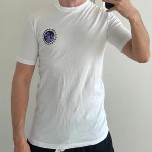 T-shirt  - Vit t-shirt med tryck fram och bak. Storlek S.