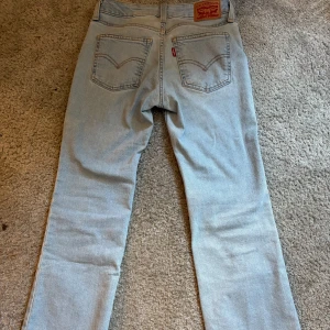 Levi's 501 ljusblå jeans, lågmidjade bootcut jeans orginal pris: 999. - Ljusblå Levi's 501 jeans med klassisk straight fit och fem fickor. Snygga kontrastsömmar och ikonisk röd Levi's-tag på bakfickan. Väldigt lågmidjade Bootcut jeans. Storlek 23, helt nya och nästan helt oanvända!🩷