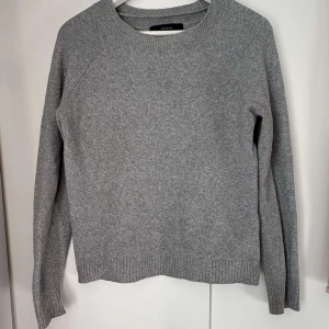 Grå stickad tröja från Vero Moda - Säljer en enkel och snygg grå stickad tröja från Vero Moda i storlek XS. Tröjan har rund hals, ribbade muddar och lång ärm. Perfekt att slänga på sig när det är lite kyligt ute. Passar dig som gillar stilrena och bekväma plagg.