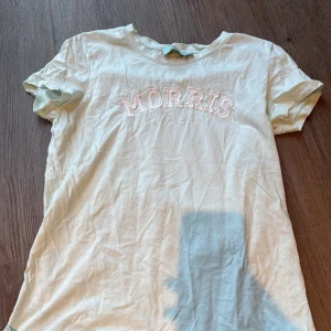 Ljus grönt-shirt från Morris Lady - Ljus grön t-shirt från Morris Lady med broderad logga i vitt på bröstet. Klassisk rund hals och korta ärmar. T-shirten är gjord i mjuk bomull och har en clean, enkel stil som funkar till jeans eller shorts. Perfekt för dig som gillar stilrena plagg med diskret branding.