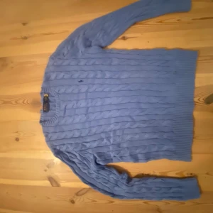 Blå kabelstickad tröja Polo Ralph Lauren - Snygg blå kabelstickad tröja från Polo Ralph Lauren i storlek M. Den är endast använd 1 gång då den är alldeles för liten för mig! Den är helt ny annars! Nypris 2600