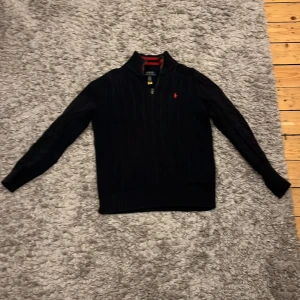 Ralph lauren halfzip - En mörk blå Ralph lauren halfzip med rött märke. Har blivit för liten sen jag köpte den i våras. Inga fläckar eller hål vad jag kan se.
