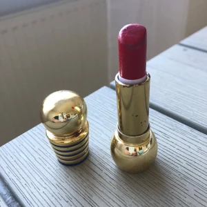 Diorific Rouge Bingo läppstift röd - Lyxigt läppstift från Dior i nyansen Rouge Bingo 013. Färgen är intensivt röd med en krämig finish. Hylsan är i guld med rundad form och blå detaljer, riktigt elegant och ikonisk design. Perfekt för dig som vill ha ett statement på läpparna.