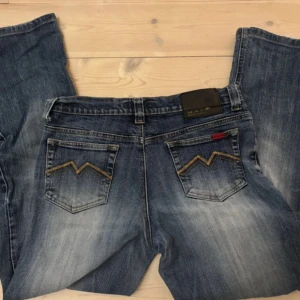 Blå jeans från M.A.P.P med broderade fickor - Säljer ett par blå jeans från M.A.P.P med snygga broderade bakfickor. Passar runt M-S