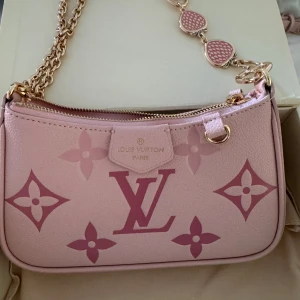  rosa handväska med kedja - Säljer en helt ny lyxig rosa handväska ,Väskan har guldfärgad kedja och detaljer, samt dragkedja upptill. Materialet är skinn, Perfekt för dig som gillar statement pieces. Skicka med sitt box