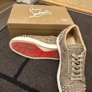 Christian Louboutin grå mocka sneakers - Köpt för nästan 2 år sedan och använt den ett par gånger, men säljer dem billigt  för att jag knappt använder den på grund av att jag har bytt stil, därför ligger dem hemma i boxen och sover. Den har tappat en spik vid vänser häl men synns knappast. Men rekomenderar dem till dig som vill ha lite lyxigare skor.