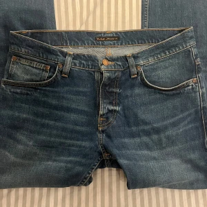 Blå jeans från Nudie  - Säljer ett par klassiska blå jeans från Nudie Jeans Co i storlek 33/34 (sitter som 32/34). De är raka i modellen och har en normal passform. Väldigt fint skick, knappt använda. Nypris 1600kr, mitt 449kr. Hör av dig vid frågor eller fler bilder😃