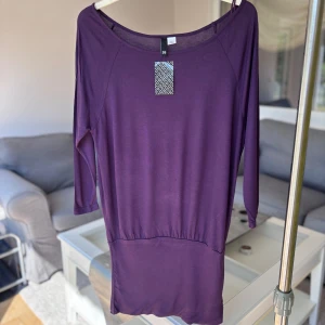 Tunika - Rund halsringning och trekvartsärmar,  markerad midja med lätt rynkning. Mjukt och följsamt material som känns skönt mot huden. 