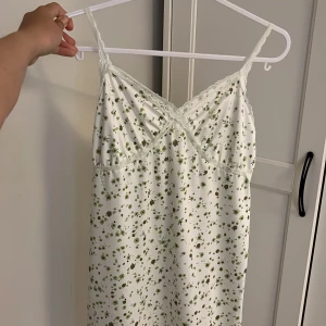 Vit blommig klänning med spets😜 - Superfin klänning i vit med grönt blommigt mönster. Perfekt för varma dagar och chill häng. Materialet känns lätt och svalt🙏🏼