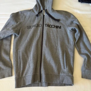 Grå hoodie från Sergio Tacchini - storleken är XL men är som en L