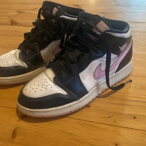 Nike Air Jordan 1 svart/vit/rosa - Nike Air Jordan 1 sneakers i svart, vitt och rosa.   Dom är lite smutsiga men ändå ok skick. Original lådan finns med den är i ganska dåligt skick. Säljs pga blivit för små :( Skicka för fler bilder 