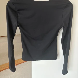 Topp med öppen rygg från Venderbys - Svart långärmad topp från Venderbys med öppen rygg. Endast använd fåtal gånger