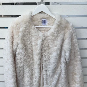 Beige pälsjacka från Saint Tropez - Fluffig och supermjuk beige pälsjacka från Saint Tropez. Jackan har rund halsringning, långa ärmar och stängs med tryckknappar framtill. Så fint skick 