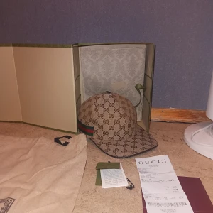 Gucci keps (Beige) - Tja, säljer då min Gucci keps som är i färgen (Beige). Den är i väldigt väldigt god skick, har användt den på vissa lägen max 10 gånger. Väldigt fräsch och inga problem med den.   Säljer den då jag inte längre har användning för kepsen. Självklart (ÄKTA). Finns kvitto på kepsen så som ni ser.   Vid en snabb och smidig affär skulle jag kunna tänka mig gå ner i någon 100 lapp, så det är bara att slå en pling.   MVH.... 