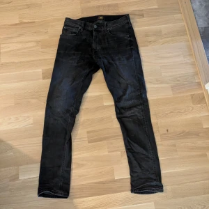 Svarta Luke jeans från Lee W31 L32 - Snygga svarta jeans från Lee i modellen Luke. De har en slim passform med en snygg tvätt.
