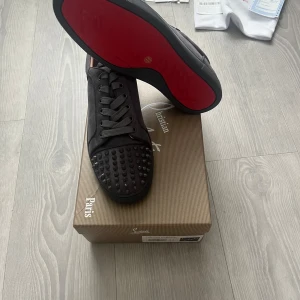 🔥Christian Louboutin Sneakers  - Christian Louboutin Sneakers – Storlek 44 Exklusiva och trendiga sneakers i grå mocka med ikoniska nitar framtill och den berömda röda sulan. En riktig statement-piece som kombinerar lyx med edgy design. Skorna är i mycket fint skick och levereras med originalkartong och tillbehör – perfekta för dig som vill sticka ut med stil! 👟✨ Tveka inte att höra av dig för pris 🤩 📦 Skickas samma dag!  🧵 Material: Grå mocka med nitdetaljer 🎨 Färg: Grå 📏 Storlek: EU 44 💥 Röd sula – signatur från Louboutin ⚡️ N