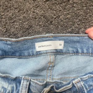 Ljusblå jeans från Gina tricot , 32 - Säljer ett par ljusblå jeans från Gina tricot, lågmidjade utsvängda byxor, tillverkade i mjukt denimtyg. Perfekta för en avslappnad och stilren look.