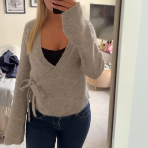 Grå omlott kofta med knytband - Säljer denna supermysig gråa omlott tröja/ kofta som är slutsåld ifrån Gina tricot. Den är i storlek S!