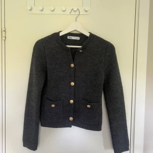Mörkgrå kofta från Zara med guldknappar - Mysig mörkgrå stickad cardigan jacka från Zara med guldknappar framtill och två fickor. Klassisk rak modell med rund halsringning och långa ärmar. Endast testad!💕💕💕
