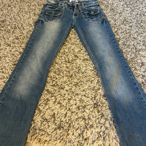 Lågmidjade utsvängda jeans  - Fina vintage jeans! Unika och coola detaljer. Innerben: 75 cm, midja rakt över: 38 cm Kom privat för fler mått eller frågor🥰