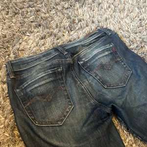 Replay jeans dam - Säljer ett par Replay Pearl jeans i klassisk blå tvätt med snygga slitningar och kontrastsömmar. Modellen har raka ben och har Replay-logga. Dom är lågmidjade 