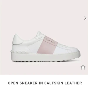 Valentino Garavani Open sneakers rosa/vit - Snygga Valentino Garavani Open sneakers i vitt kalvskinn med bred rosa läderdetalj över mitten. Klassisk låg modell med snörning och diskret logga på plösen. Sulan är vit och har nitar baktill. Köpta för 7000 så säljer för 3000, men pris går att diskutera vid snabb affär, fint skick!💓Storlek 39 ungefär & innersulan är 25cm❤️Kontakta mig innan ni köper