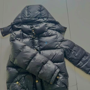 Svart dunjacka från Ralph Lauren M - Säljer en svart dunjacka från Ralph Lauren i storlek M. Jackan har huva, blå broderad logga på bröstet, knappar och dragkedja framtill samt praktiska fickor med tryckknappar. Perfekt för kalla dagar och riktigt snygg passform, jackan passar alla längder från 145-155 beroende på hur man vill att den sitter, vill man ha den inte för stor och inte för liten passar den 145 150-155 sitter den lite slim. Priset kan diskuteras. Skick 8/10