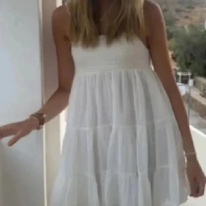 Vit sommarklänning med volang - Säljer en söt vit klänning med volangdetaljer och smala axelband som har bara använts 2 gånger,  den är från Gina Young i storlek 158. 