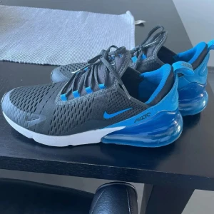 Nike Air Max 270 sneakers svart/blå - Säljer ett par Nike Air Max 270, säljer pga att de inte passar, ser lite smutsigare ut i verkligheten men allt borde gå bort, men bara lite, mer bilder? Kontakta mig