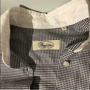 Svartvit rutig skjorta från Stenströms - Klassisk skjorta från Stenströms i svartvitt rutigt mönster. Skjortan har vit krage och vita manschetter, knäppning framtill och lång ärm. Perfekt för en stilren och tidlös look.