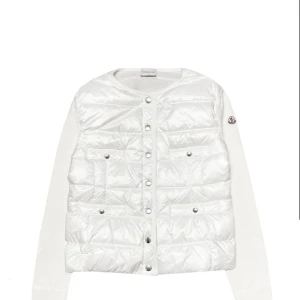 Vit quiltad cardigan jacka från Moncler - Säljer en snygg vit cardigan jacka från Moncler med quiltad front och stickade ärmar. Jackan har rund hals, tryckknappar och två fickor framtill. Säljer för 4500 eftersom att jag använt den mycket. Självklart är den äkta och har äkthetsbevis och kvitto. Kom privat för mer frågar 🩷