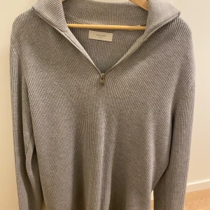 Grå jack&jones half zip tröja - Säljer en grå half zip stickad tröja i storlek L. Tröjan är i bra skick. Väldigt enkel att matcha med det mesta. Säljer då jag ej använder den längre