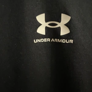 Svart långärmad kompressionströja från Under Armour - Säljer en svart långärmad kompressionströja från Under Armour HeatGear. Tröjan har en tight passform och är perfekt för träning eller sport. Klassisk logga på bröstet och tillverkad i syntetmaterial som andas. Och den har inga slitningar överhuvudtaget nypris ca.400